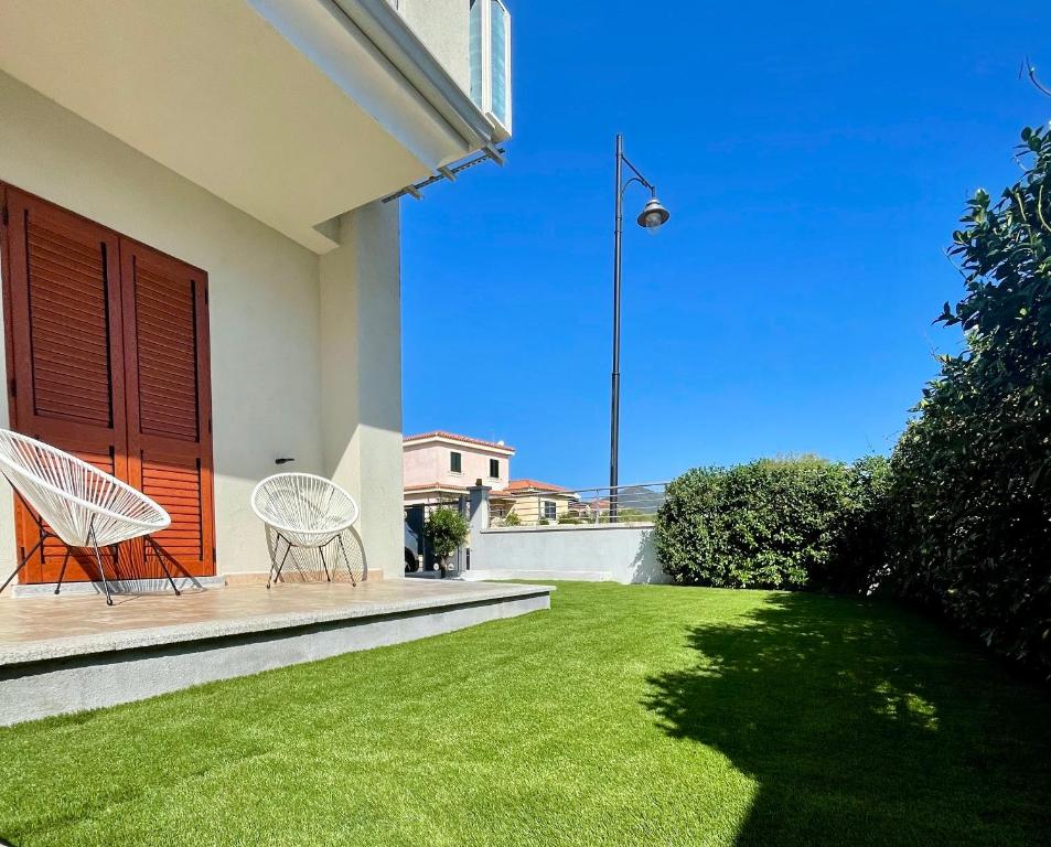 - deux chaises sur une terrasse couverte avec une pelouse dans l'établissement Casa Fralia, à Olbia