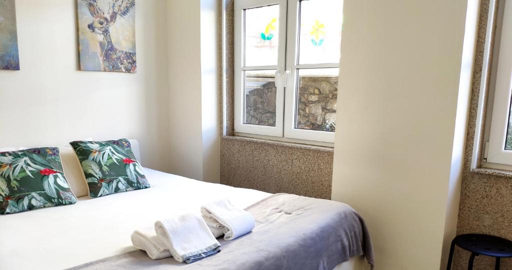 a bedroom with a bed with two towels on it at Casa do Recanto - Private Suite in Porto