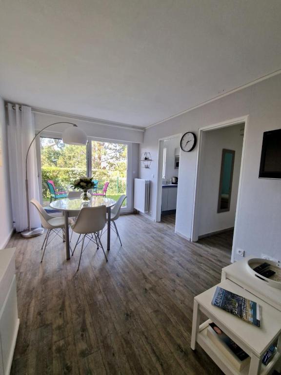 une salle à manger et un salon avec une table et des chaises dans l'établissement Rez-de-jardin bord de mer, à Cabourg