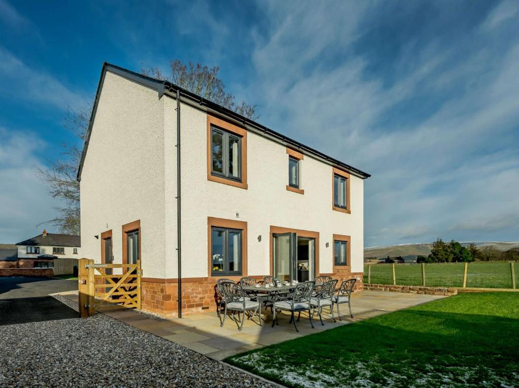 a house with a table and chairs on a patio at 4 Bed in Eden Valley 89353 in Little Salkeld