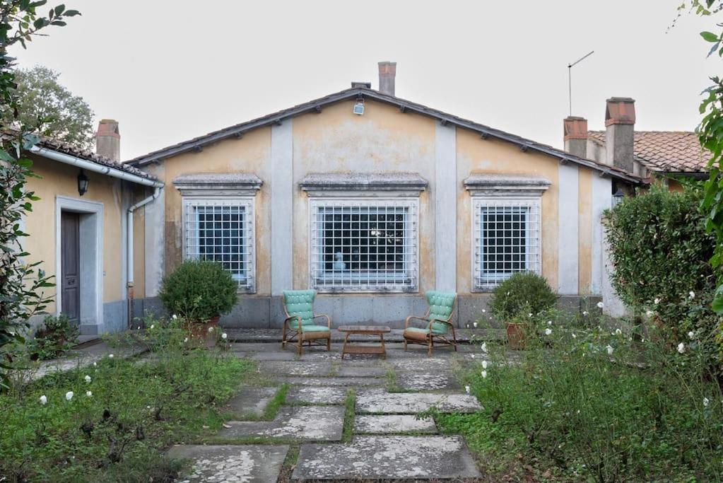 uma casa com duas cadeiras e uma mesa num quintal em Villa Cicas em Manziana