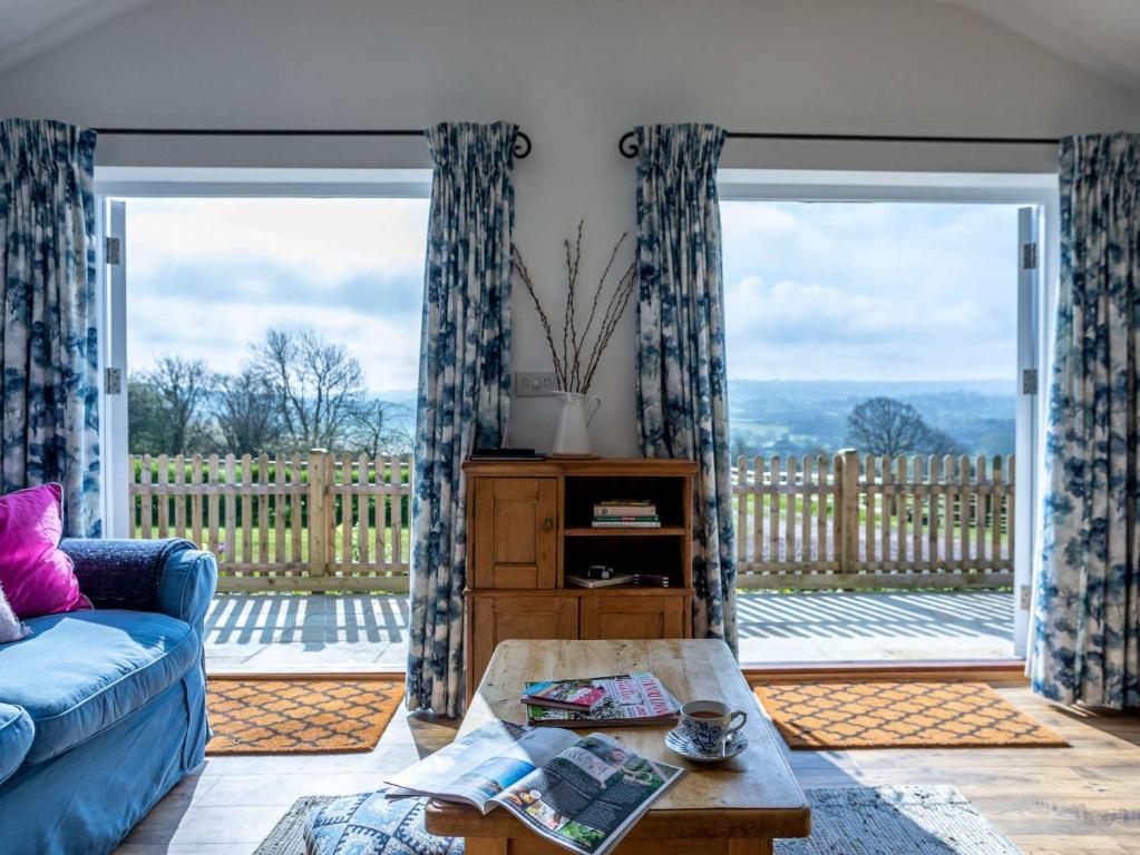 a living room with a couch and a large sliding glass door at 1 Bed in Axminster 82604 in Chardstock