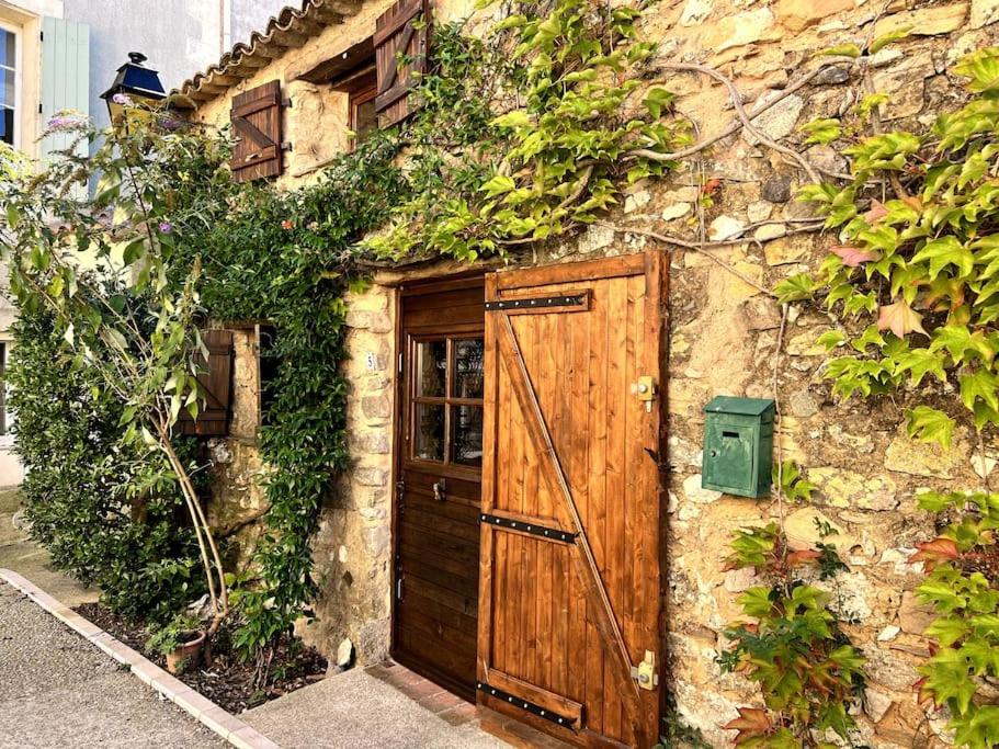 an old stone building with a wooden door at La Maison De Blanche Neige in Assignan