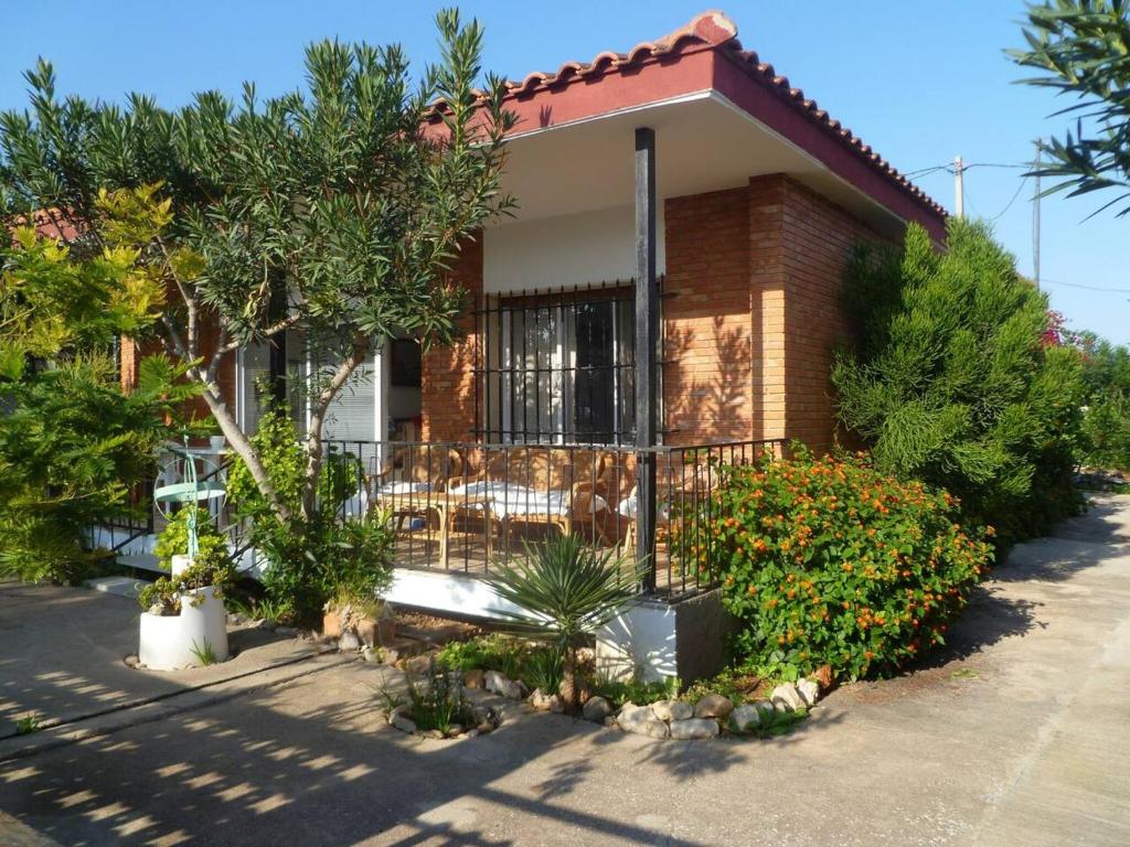 a brick house with a porch and some plants at 3 bedrooms house at Alcanar 100 m away from the beach with terrace and wifi in Alcanar