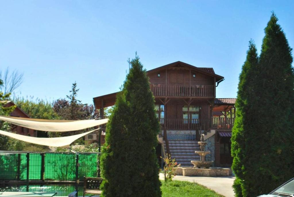 a large wooden house with a tree at 5 bedrooms chalet with shared pool jacuzzi and terrace at Alcaniz in Alcañiz