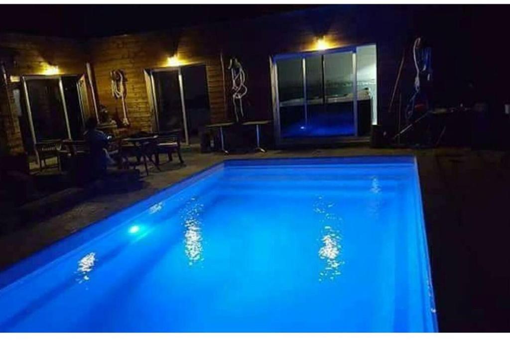 a large blue swimming pool in a dark room at Propriete de 3 chambres avec piscine partagee jacuzzi et wifi a Chauffry in Chauffry