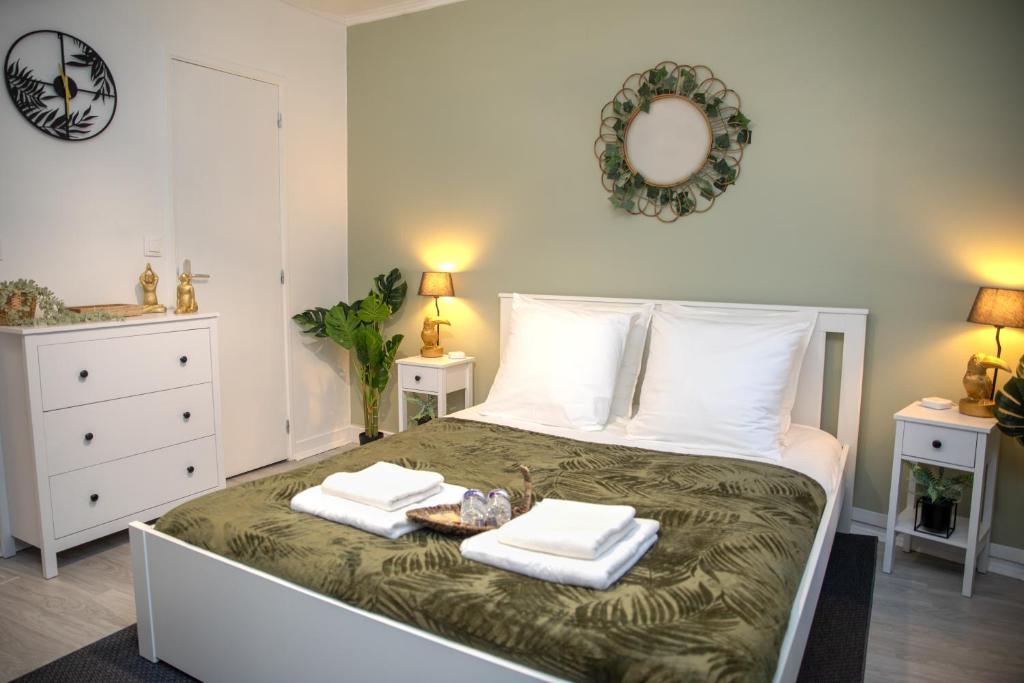 um quarto com uma cama com duas toalhas em Le Tropicana - Proche Roissy CDG - Paris - Astérix em Dammartin-en-Goële