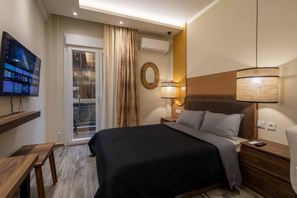 a bedroom with a large bed and a television at GPX CLR GuestSuite No1 in Larisa