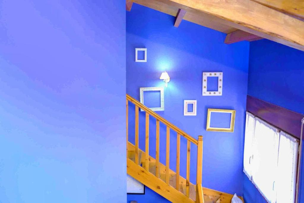 Habitación azul con una escalera con cuadros en la pared en 2 bedrooms property with wifi at Avila, en Ávila