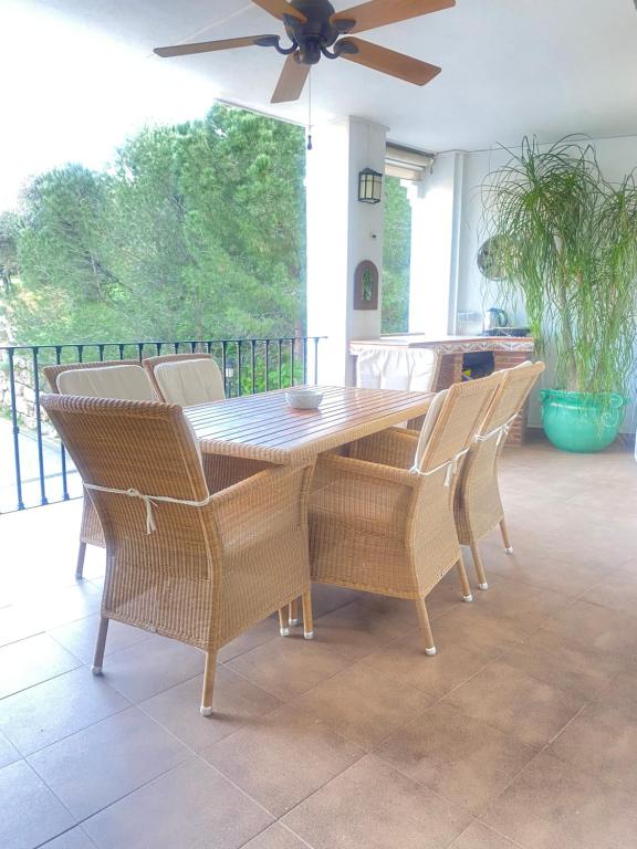 un tavolo da pranzo con sedie e un ventilatore a soffitto di Modern Apartment in Benahavis Village Centre with Underground Parking a Benahavís