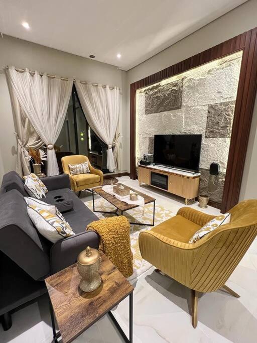 a living room with a couch and a tv at Elite Apartment 3 in Riyadh