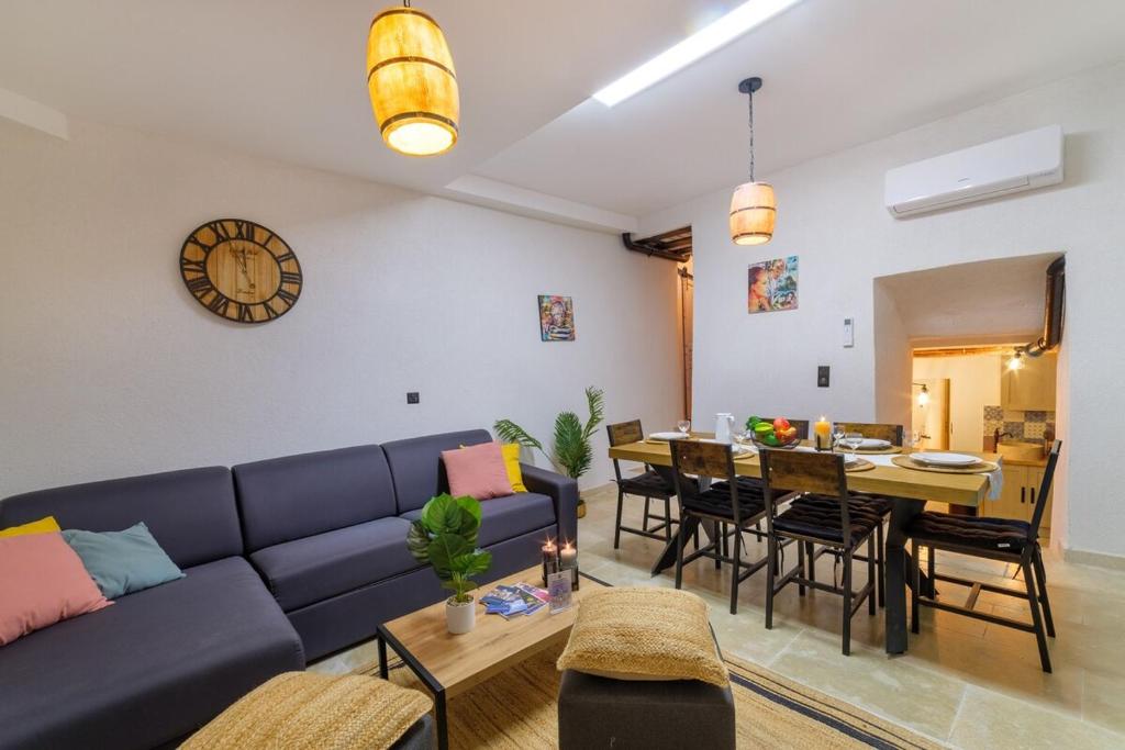 a living room with a blue couch and a table at Charmant Appartement - Saint Paul de Vence Village in Saint Paul de Vence