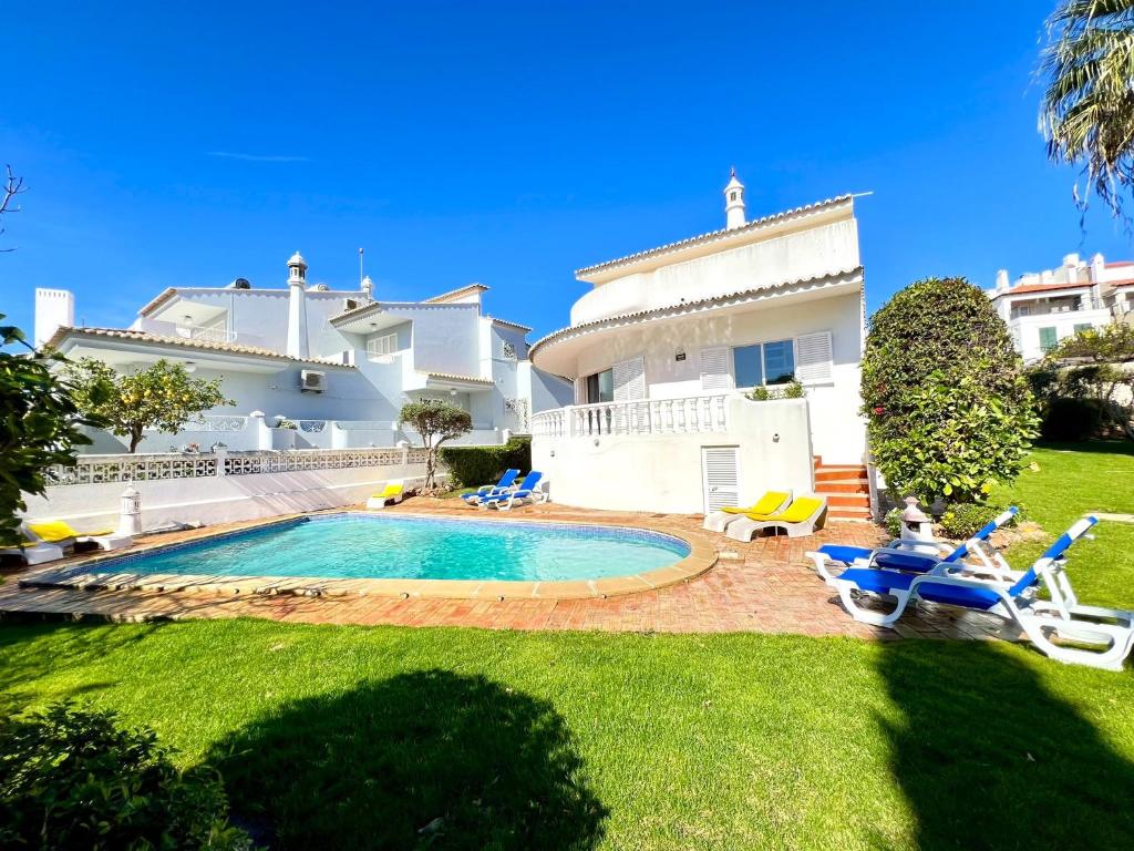 a villa with a swimming pool in front of a house at Vilamoura Brightness Villa With Pool by Homing in Vilamoura