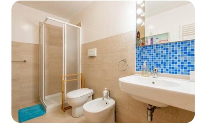 La salle de bains est pourvue de toilettes, d'un lavabo et d'une douche. dans l'établissement Camera con uso piscina vista mare, à Terra Mala