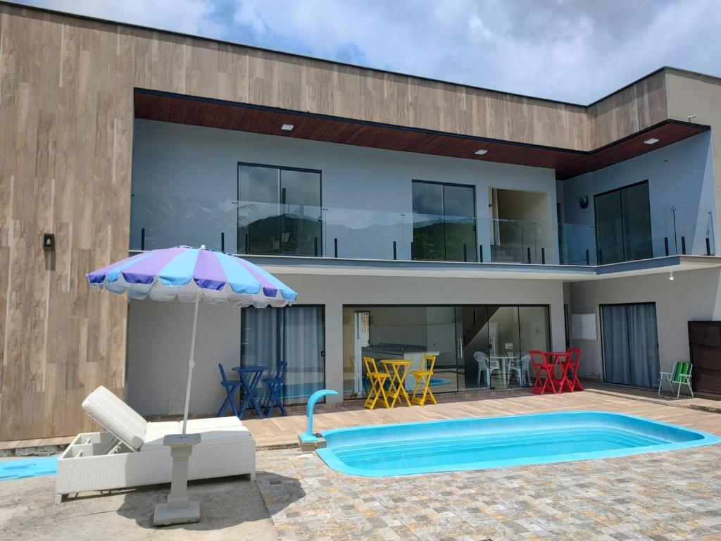 une maison avec une piscine et un parasol dans l'établissement Morada Stucchi, à Balneário Camboriú