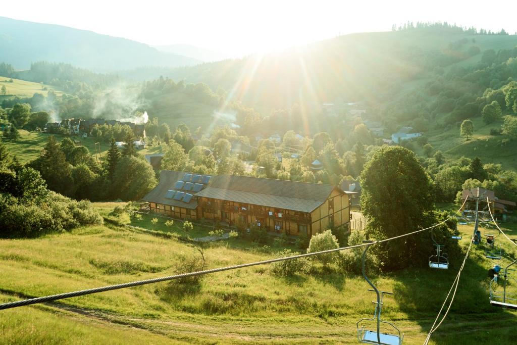 un bâtiment sur une colline avec le soleil en arrière-plan dans l'établissement IZKI Eco Resort, à Izki