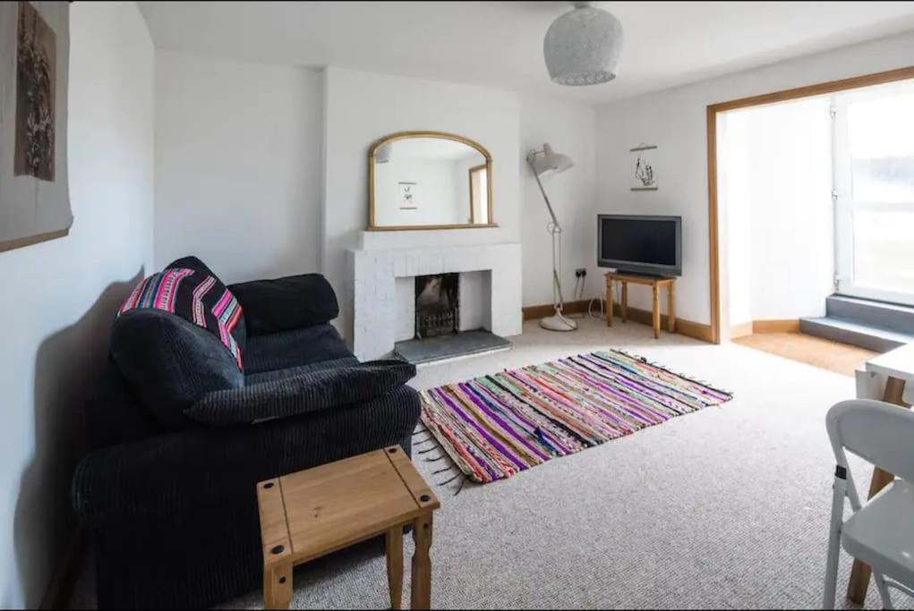 sala de estar con silla y chimenea en Spacious 2 Bedroom Apartment near Seafront, en Penzance