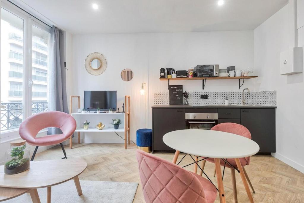 un soggiorno con tavolo e 2 sedie di Appartement cosy proche Arc de Triomphe - 4P a Parigi