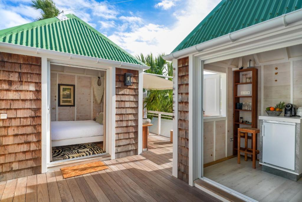 una pequeña casa de madera con techo verde en One bedroom bungalow with shared pool terrace and wifi at Saint Barthelemy, en Saint Barthelemy