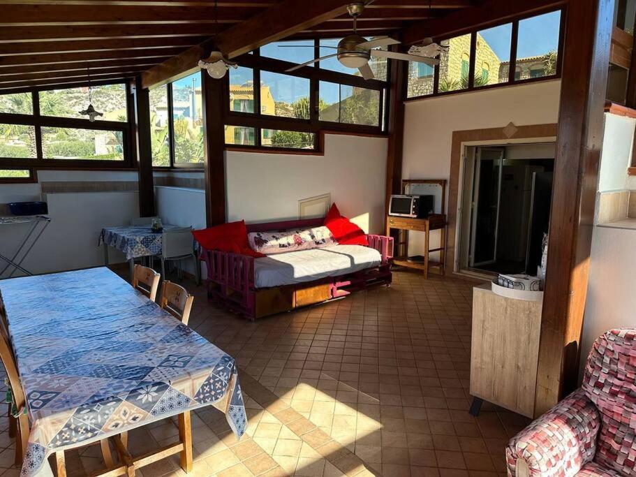 um quarto com uma cama, uma mesa e um sofá em La Dimora del Sole em Licata