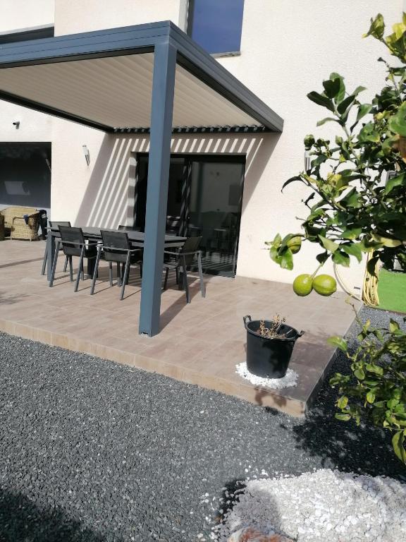 d'une terrasse avec des chaises noires et une table. dans l'établissement F2 Blanc Bleu, à Sainte-Marie-la-Mer