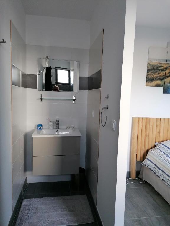 a bathroom with a sink and a bed at F2 Blanc Bleu in Sainte-Marie-la-Mer