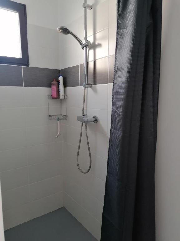a shower with a black shower curtain in a bathroom at F2 Blanc Bleu in Sainte-Marie-la-Mer