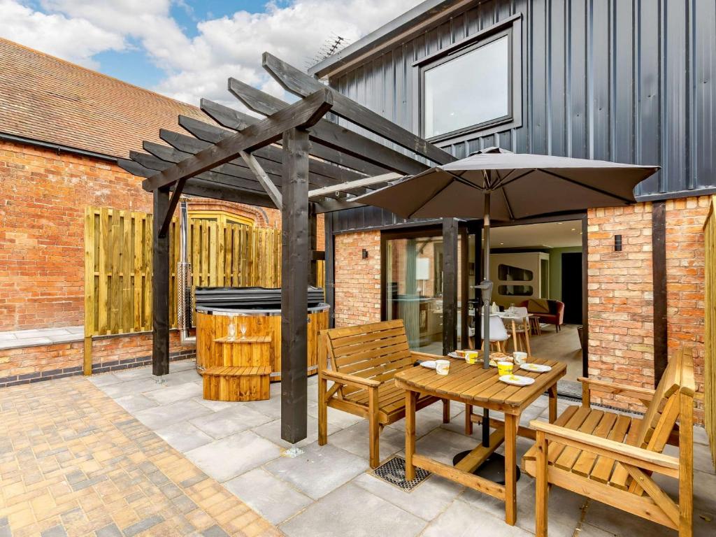 a patio with an umbrella and a table and chairs at 2 Bed in Alcester 88397 in Coughton