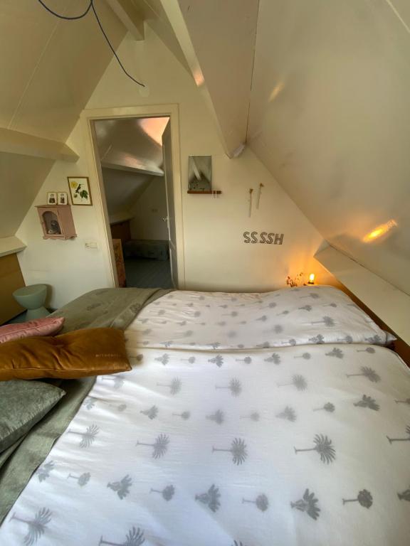 een slaapkamer met een bed op de zolder bij Romantic Dutch hideaway in Jisp