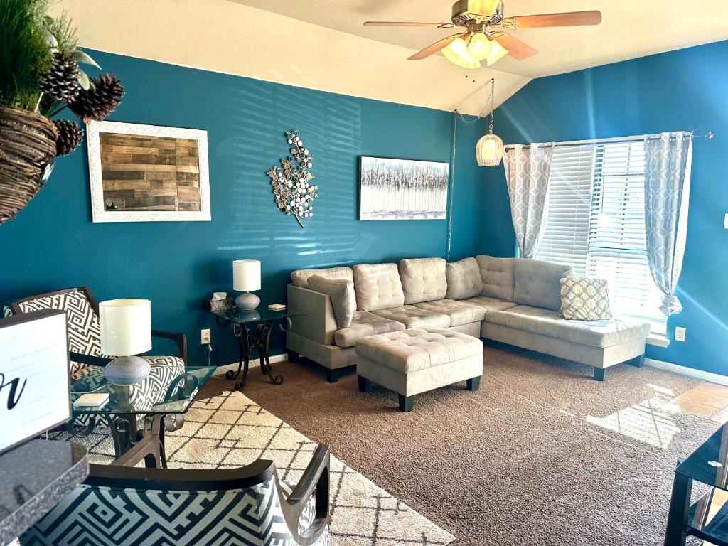 uma sala de estar com paredes azuis e um sofá em Casa Nicholas , 3 bedroom/ 2 bath with large yard em Killeen