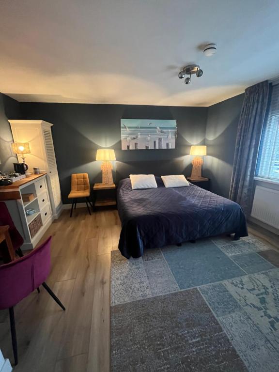 a bedroom with a bed and two lamps in it at B&B De Koog Texel in De Koog