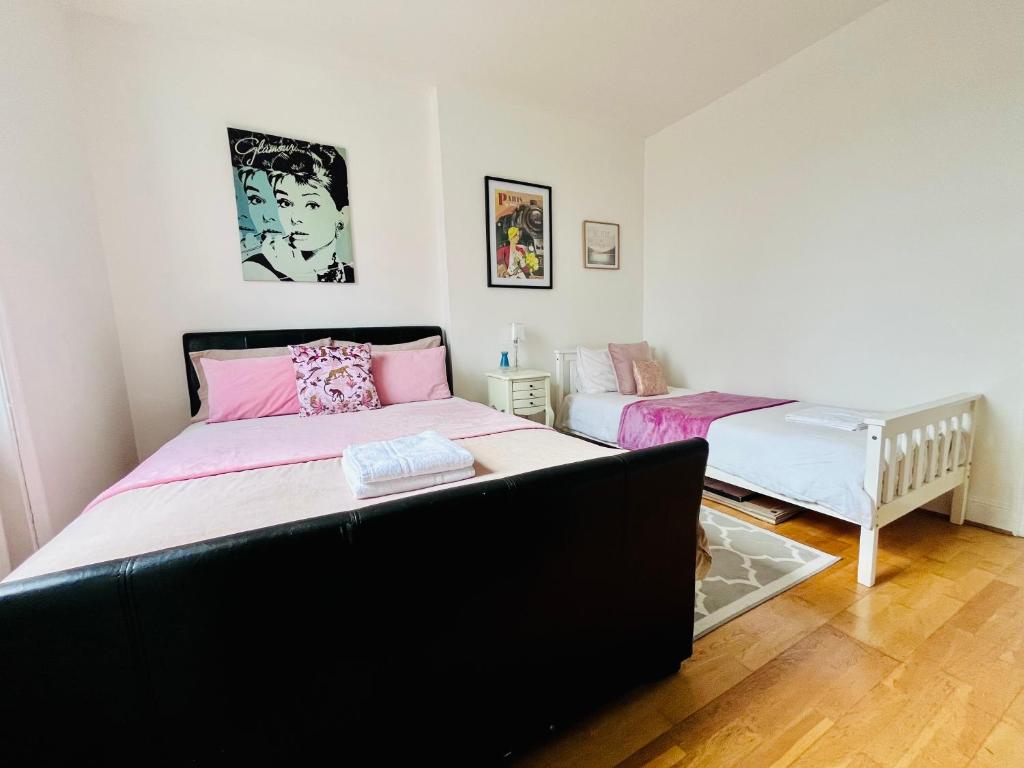 a bedroom with a large bed and a crib at Gorgeous Studio 15 Minutes from Central London in London