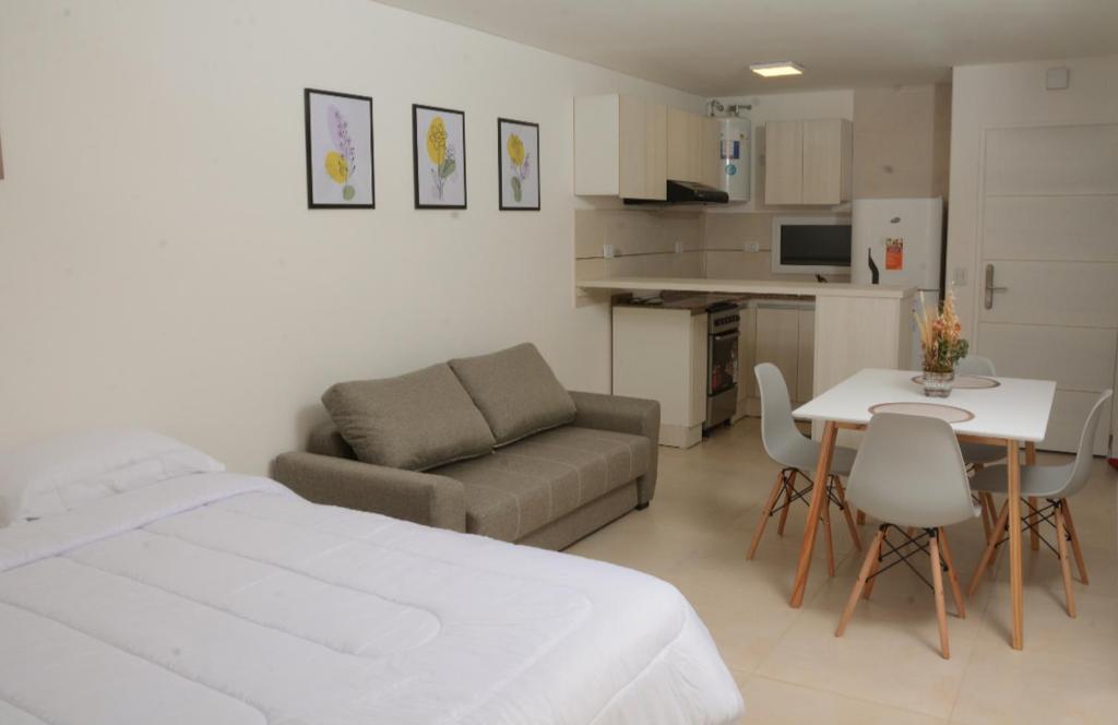 1 dormitorio con cama, sofá y mesa en Aparts VC en Villa Constitución