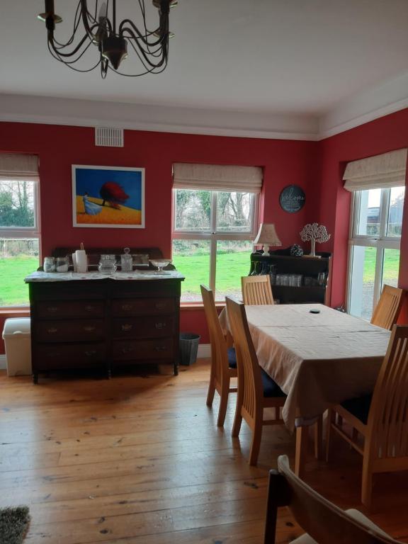 a dining room with red walls and a table and chairs at KYLEARD Ryan in Monasterevin