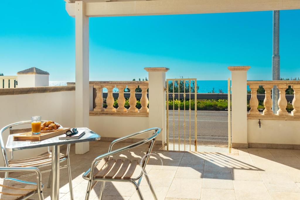 einen Tisch und Stühle auf einem Balkon mit Meerblick in der Unterkunft Oasi Marina Apartment Sea View by Diddoi in Torre Suda