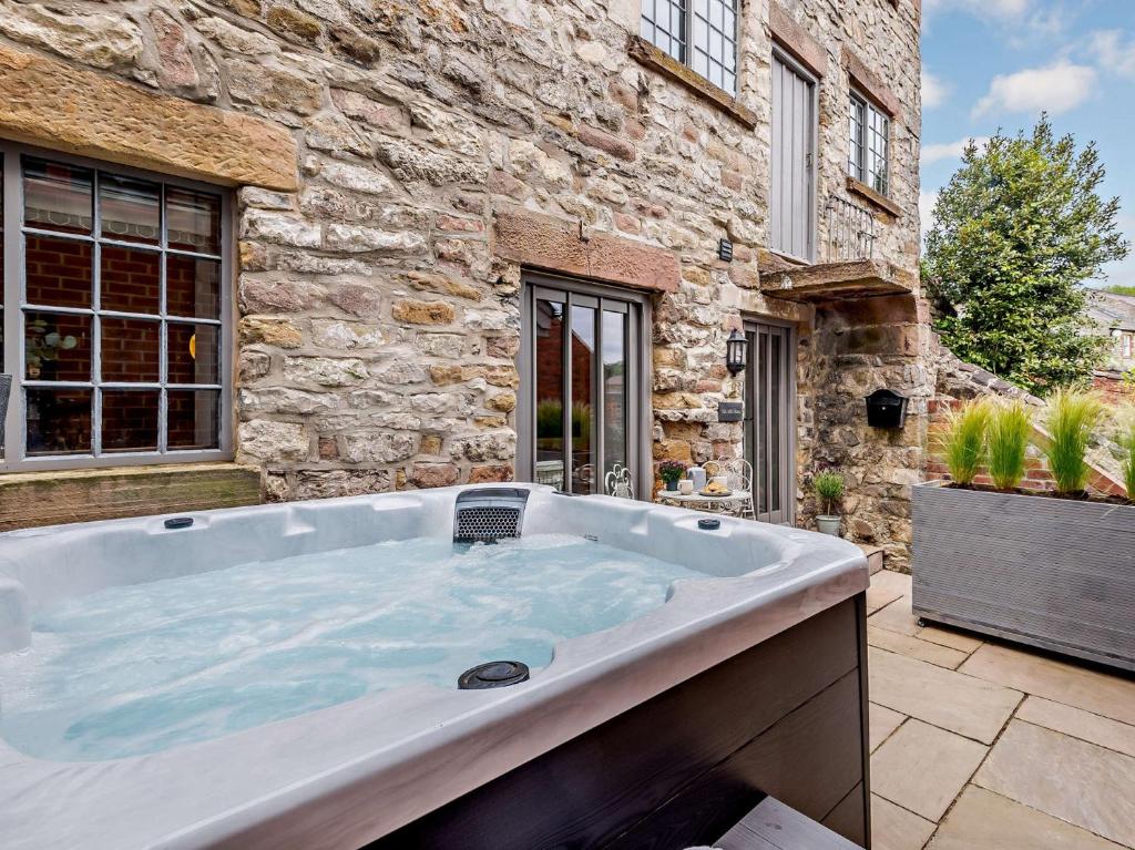a large bath tub in the backyard of a stone building at 3 bed in Wirksworth 83082 in Wirksworth