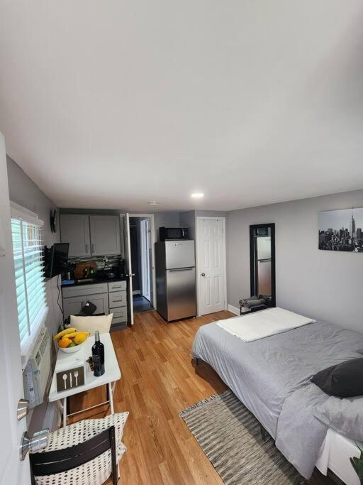 um quarto com uma cama grande e uma cozinha em Cozy studio in a lovely area em Forest Hills