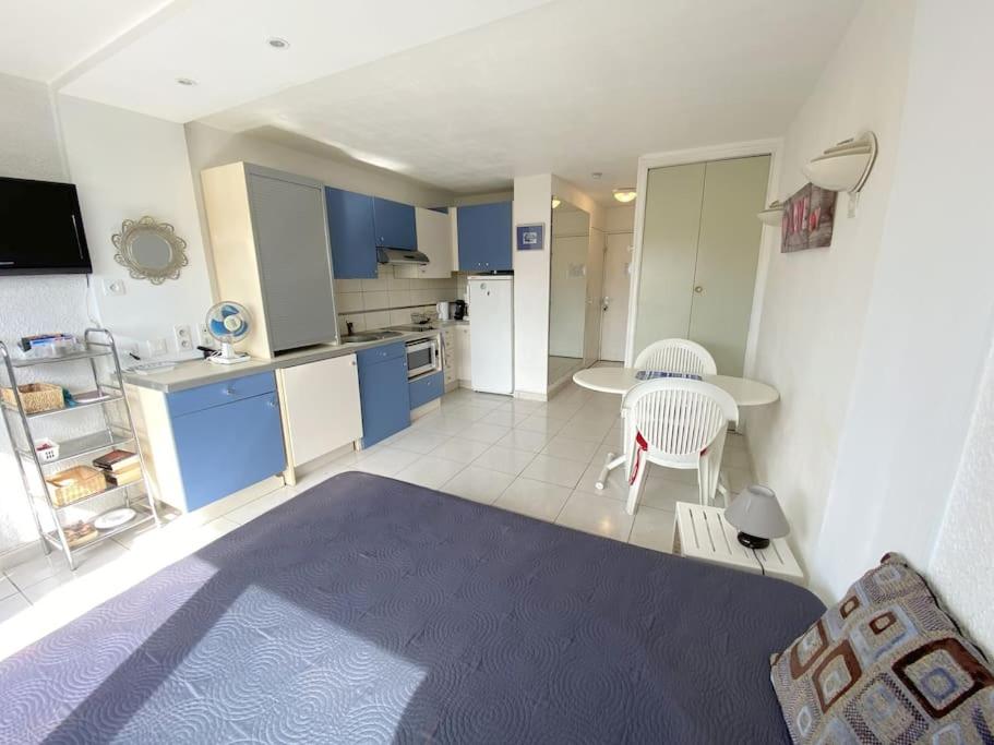 un salon avec une table et une cuisine dans l'établissement Studio 106, Port Vénus au village naturiste, au Cap d'Agde