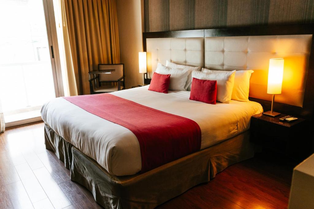 Cette chambre comprend un grand lit avec des oreillers rouges. dans l'établissement BENS - Recoleta Park, à Buenos Aires