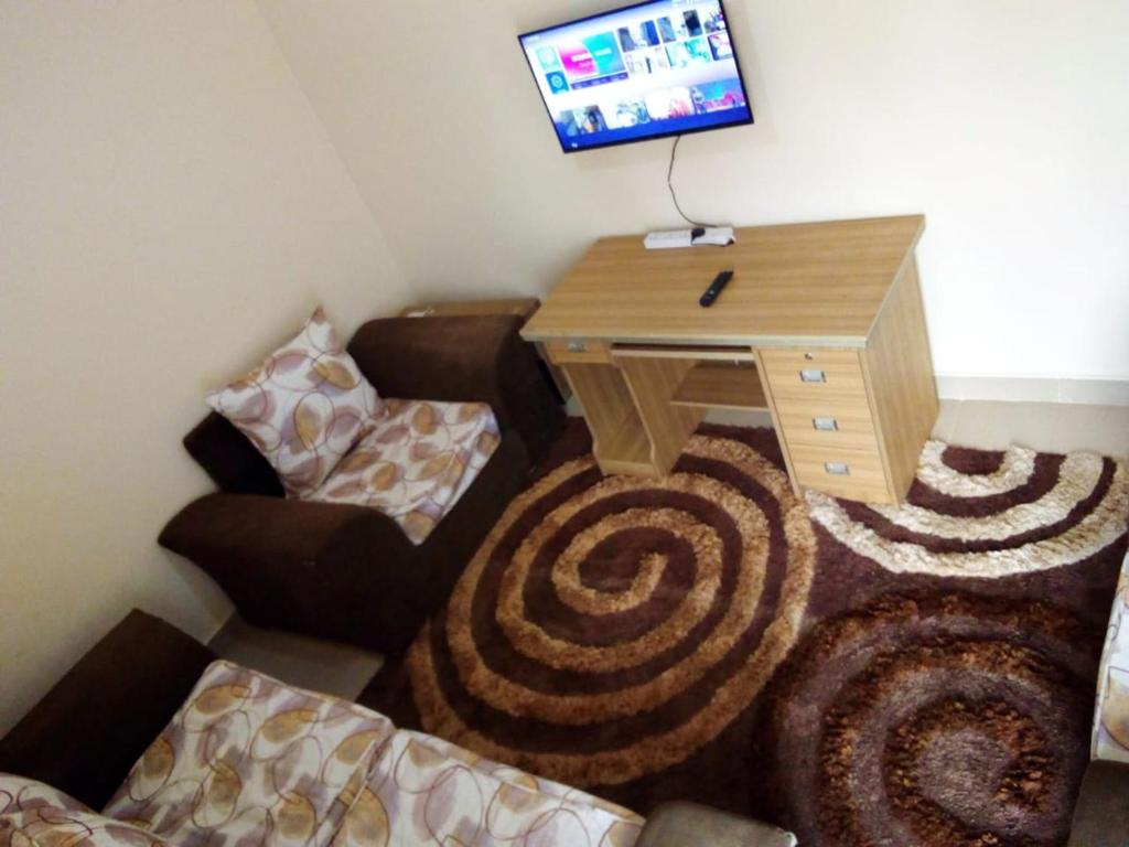 a room with a desk and a tv on a wall at Selitah Apartments in Kitale