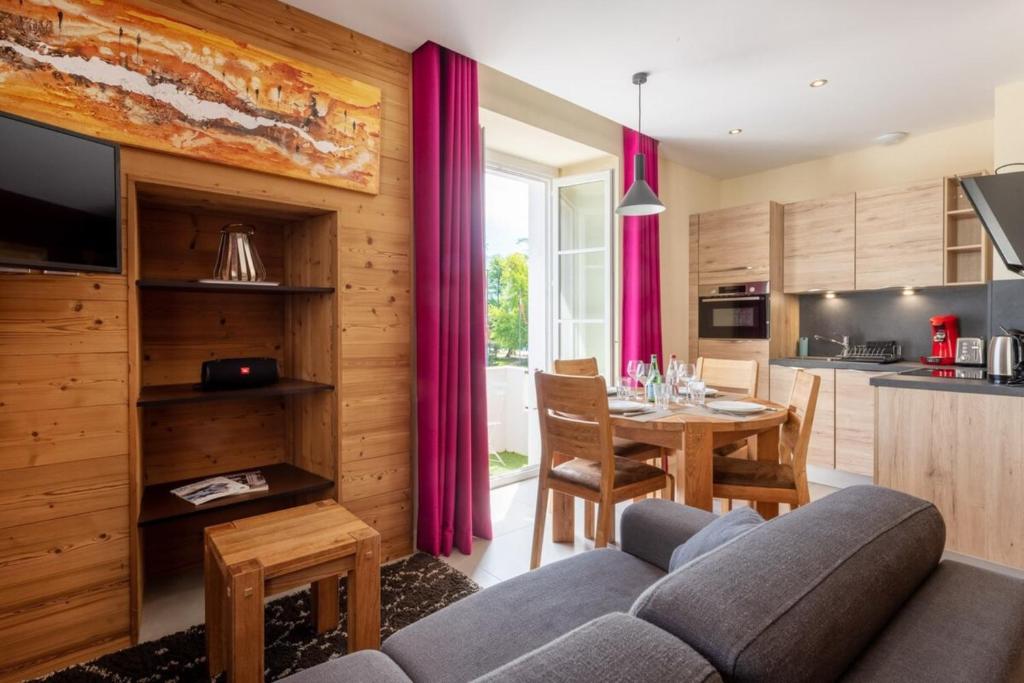 eine Küche und ein Wohnzimmer mit einem Sofa und einem Tisch in der Unterkunft CARPATES Annecy Rent Lodge in Annecy