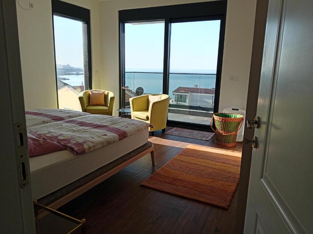 a bedroom with a bed and a view of the ocean at Apartmani Seaside in Dobra Voda