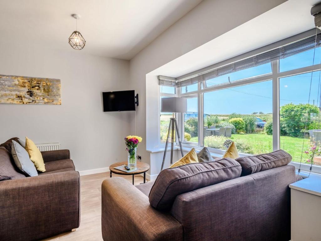 una sala de estar con 2 sofás y una ventana grande en 2 Bed in Mundesley KT152 en Mundesley