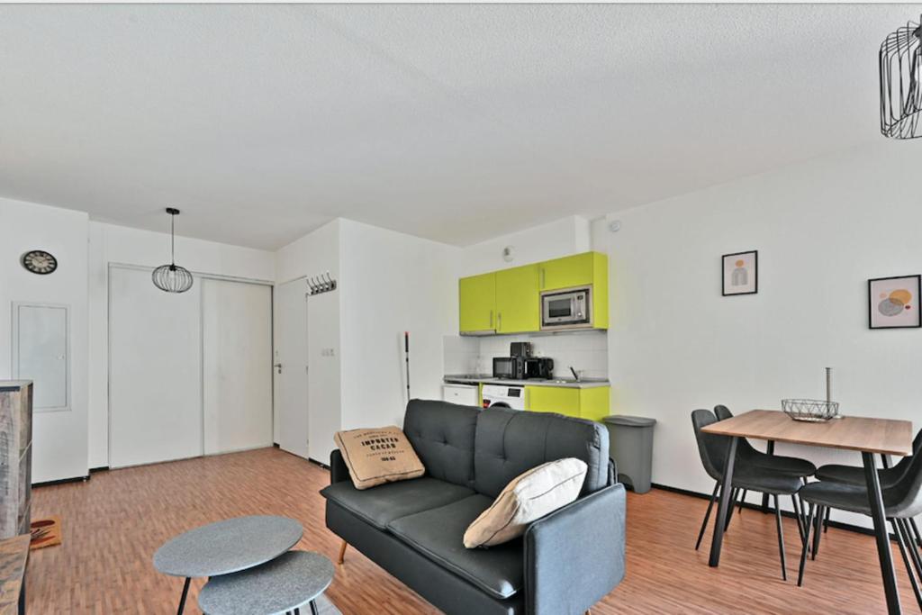 ein Wohnzimmer mit einem Sofa und einem Tisch in der Unterkunft Cosy flat close to the city centre and beaches in Montpellier