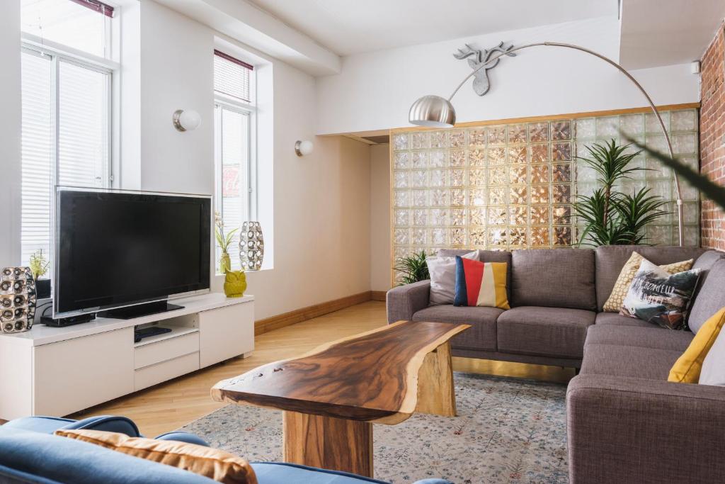 a living room with a couch and a tv at MTLVacationRentals - The City Chalet in Montréal