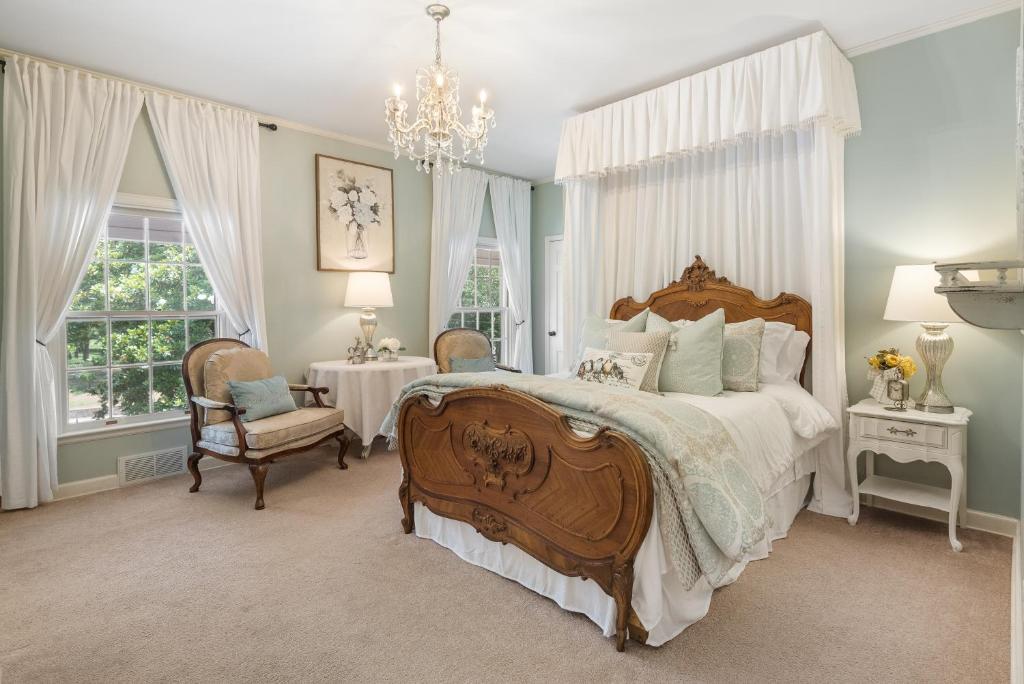 Un dormitorio con una cama grande y una lámpara de araña. en Grand Mansion-Magnolia suite!, en Fort Smith