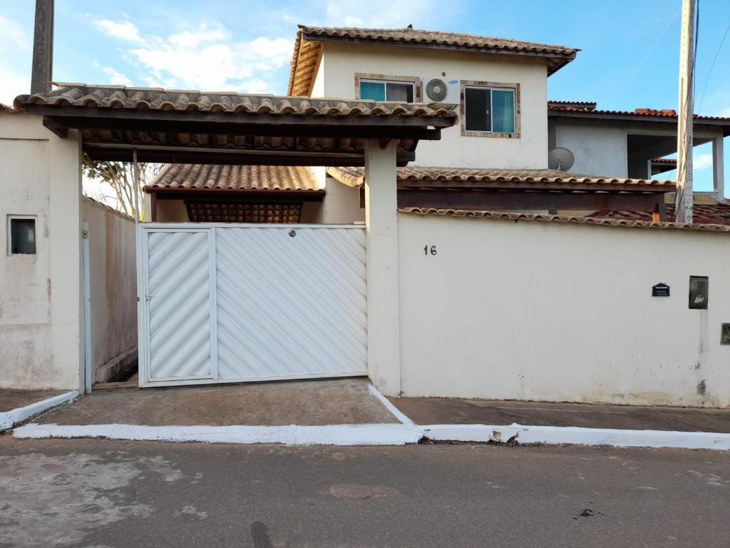 una puerta de garaje blanca frente a una casa en Casa temporada, en Búzios