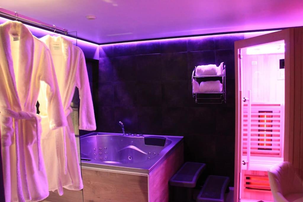 a purple bathroom with a tub and a sink at L'Ecrin duplex balnéo & Sauna in Troyes