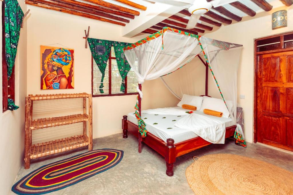 a bedroom with a bed with a canopy at Demani Lodge Zanzibar in Paje