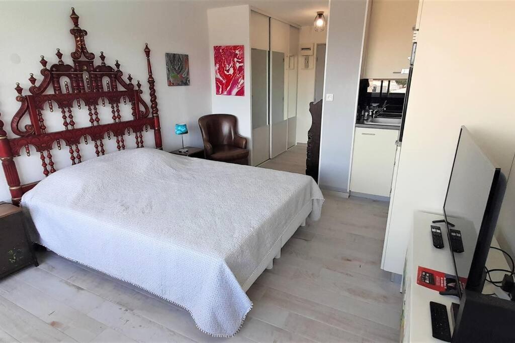 une chambre avec un lit blanc et une télévision dans l'établissement Studio 320, Port Vénus au Village naturiste, au Cap d'Agde